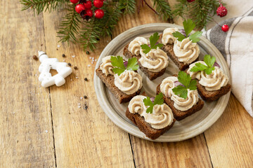 Christmas appetizer New year meal idea. Creative appetizer christmas. Creamy pate sandwiches of herring on a rye bread on the rustic table.
