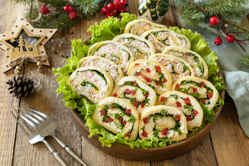 Creative appetizers christmas. Cheese roll with cream cheese, sweet pepper and greens.