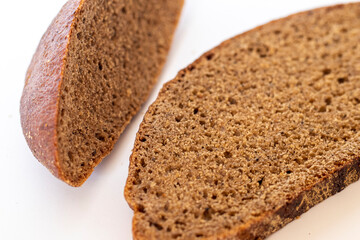 Close up shot of pieces of brown bread on white background. Food