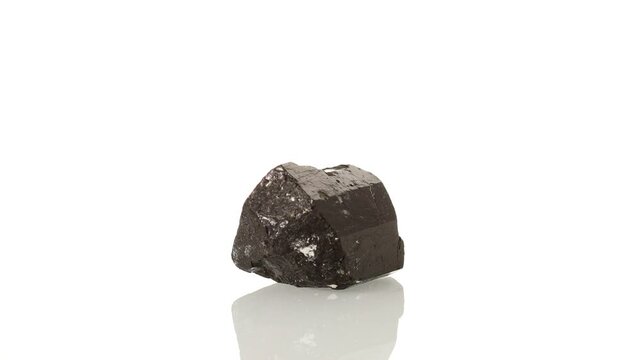 mineral stone Schorl rotates in a circle on a white background