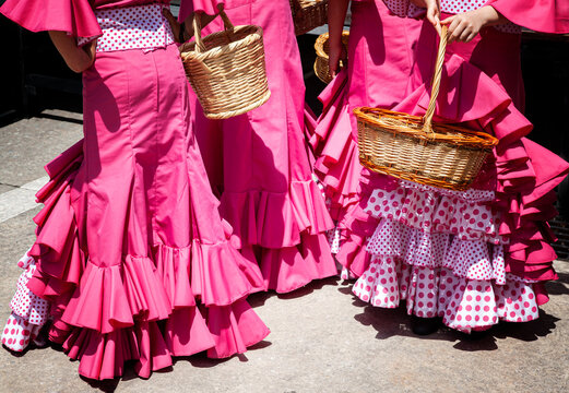traje de gitana  o flamenca de color rosa con  volantes y lunares con cestos de min&iexcl;abre para una actuaci&oacute;n en la calle