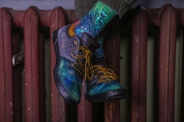  A man is sitting on a radiator with his feet painted in bright colors