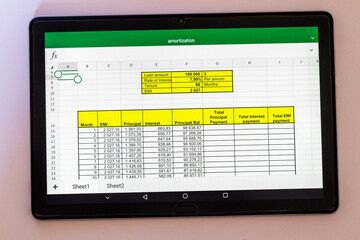 Shot of an excel sheet on tablet screen showing bank loan amortization table. Finance