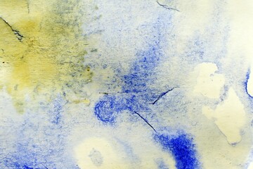 Abstract watercolor artwork featuring blue and yellow hues with textured patterns.