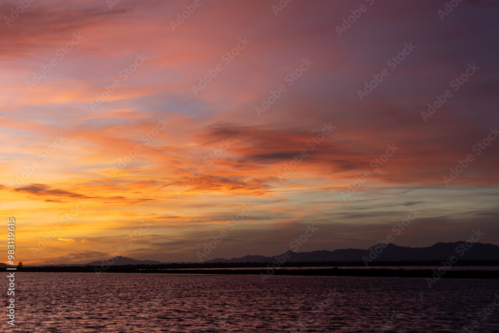 Aufkleber the setting sun is casting warm hues across the sky, creating a mesmerizing reflection on the tranqu
