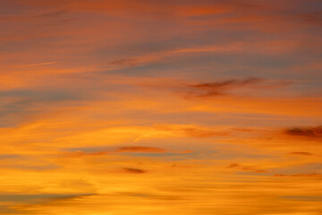 Fiery orange and yellow clouds fill the frame, creating a dramatic and colorful sunset sky perfect as a background image
