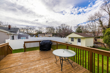 Beautiful spring view of backyard of villa with patio, green lawn, garden shed, and outdoor furniture with barbecue. New Jersey, USA