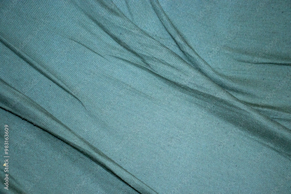 Poster a close-up of softly draped teal fabric creates a calming visual. the smooth texture and gentle fold