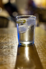 Glasses of cold mineral sparkling water served outdoor with ice cubes in cafe at night in historical Triana district, Sevilla, Spain