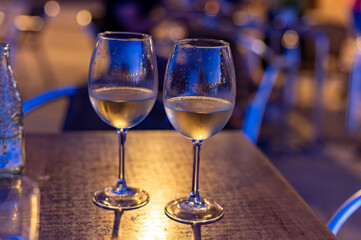 Two glasses of cold dry white wine served outdoor in cafe at night in historical Triana district, Sevilla, Spain, close up