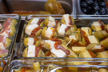 Pickled and marinated olives, artichokes, vegetables on farmers market, variety of tasty tapas in Andalusia, Spain