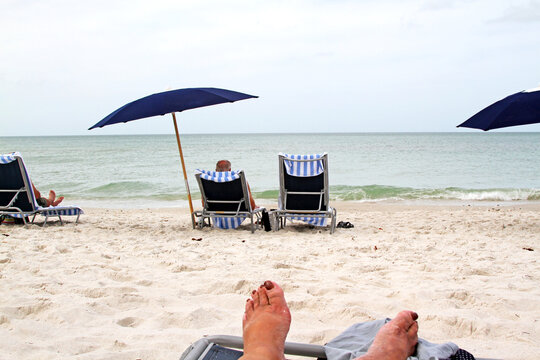 Beach chairs and umbrella on a sandy beach with ocean in background	
