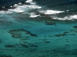 tropical coastal sea and coral reef seen from high angle view, turquoise and deep blue water and waves in the ocean