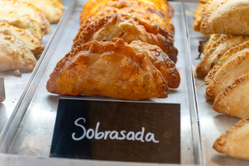 Traditional Spanish and Latin American pies empanadas with different fillings, at farmer's market in bakery, wirh Spanish sobrasada sausage