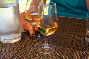 Tasting of Bordeaux white wine in Sauternes, left bank of Gironde Estuary, France. Glasses of white sweet French wine served in restaurant