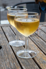 Tasting of Bordeaux white wine in Sauternes, left bank of Gironde Estuary, France. Glasses of white sweet French wine served in outdoor restaurant