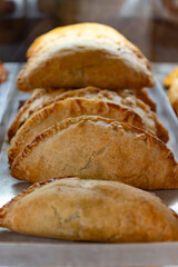 Traditional Spanish and Latin American pies empanadas with different fillings, at farmer's market in bakery