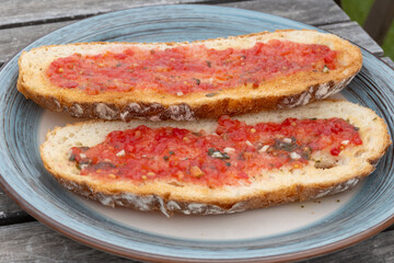 Traditional andalusian breakfast on roof patio with bread toasts, fresh ground tomatoes sauce and...