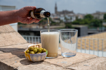 Spanish beer and bowl with green andalusian olives served on outdoor roof terrace with view on central part of old Sevilla, Andalusia, Spain