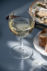 Plate with fresh live oysters with citron, bread, butter and white wine served at restaurant in oyster-farming village, Arcachon bay, Gujan-Mestras port, France