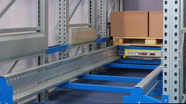 A pallet of boxes is being moved by a conveyor in a logistics warehouse, logistics concept