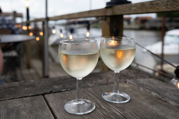 Tasting of Bordeaux white wine, right bank of Gironde Estuary, France. Glasses of white sweet French wine served in outdoor restaurant on oysters farm in Gujan-Mestras, Arcachon bay