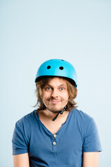 Man, bicycle helmet and studio portrait with mockup space for safety for trip by blue background. Person, hardhat and smile for eco friendly transportation for journey, travel or cycling in Germany