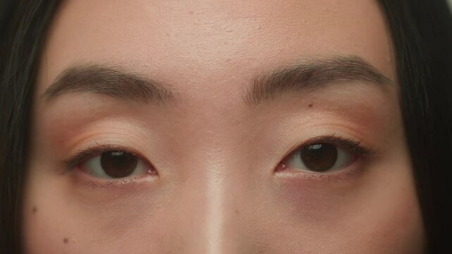 Macro extreme close up Asian woman female dark eyes face details korean japanese chinese girl model eyeball iris eye open eyesight gaze vision blink eyelashes skin care medical surgery beauty health