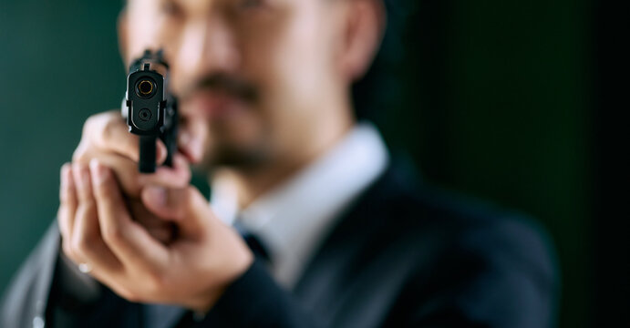 拳銃を持つ髭の男性