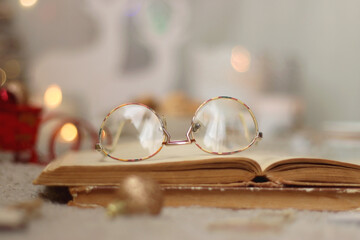 Various Christmas decorations, lit candles, cup of tea or coffee, cookies, books, presents and soft...