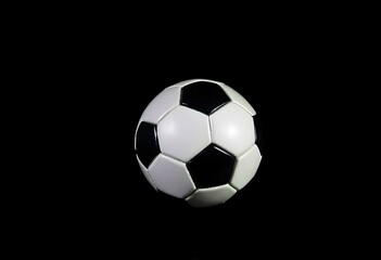 Soccer ball on a dark surface, illuminated by a single overhead light, casting shadows around it create with ai