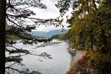 A serene river winding through a forested landscape with autumn foliage.