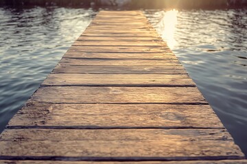 Obraz premium Wooden dock extending into the water, sunset on the lake. Abstract path to a new horizon.
