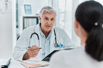 Mature doctor, patient and appointment in office clinic for healthcare, checkup or advice. Medical professional, woman and conversation for help, exam or results on clipboard in hospital consultation