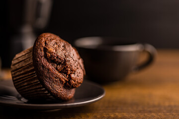 Sweet chocolate muffin cakes on plate on wooden table.