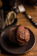 Sweet chocolate muffin cakes on plate on wooden table.