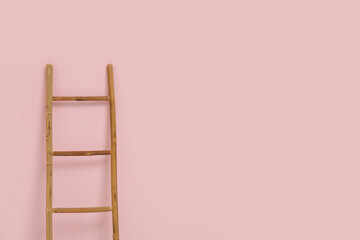 Wooden ladder near pink wall in room