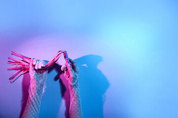 Woman with whip from sex shop on color background