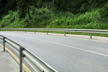 Asphalt road in forest on summer day