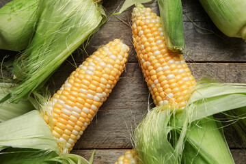 Fresh corn cobs on wooden background