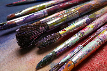 Fototapeta premium Dirty paint brushes on colorful background