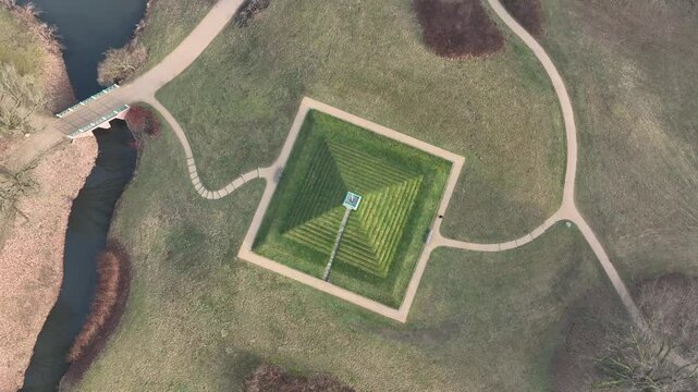 the historic land pyramid with a nearby river and leafless trees in Branitz Park in Cottbus, Germany
