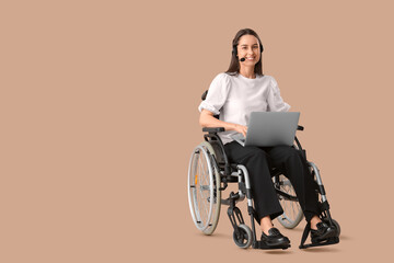 Female technical support agent in wheelchair with headset and laptop on beige background