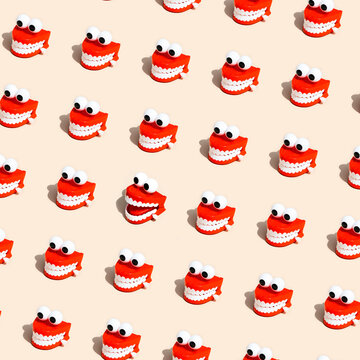 Repeating pattern of chattering teeth toys on beige