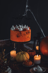 Beautiful table with homemade delicious cake for Halloween party with meringue ghosts and chocolate...