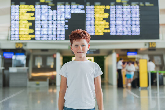 Young boy stands smiling at the airport departure terminal