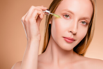 Fototapeta premium Photo of stunning sexy lady nude shoulders apply cheek serum isolated beige color background