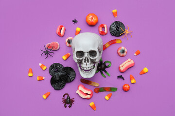 Composition with human skull and different candies for Halloween on color background