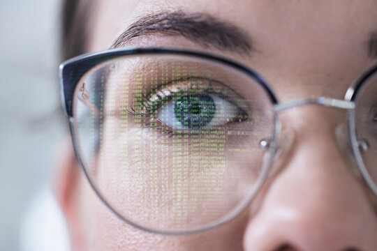 Closeup, portrait or woman with glasses and coding reflection for vision, eyes healthcare or wellness. Innovation, half face or programmer reading online code software for development on computer