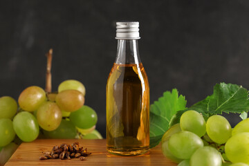 Bottle of cosmetic grape seed oil on black background